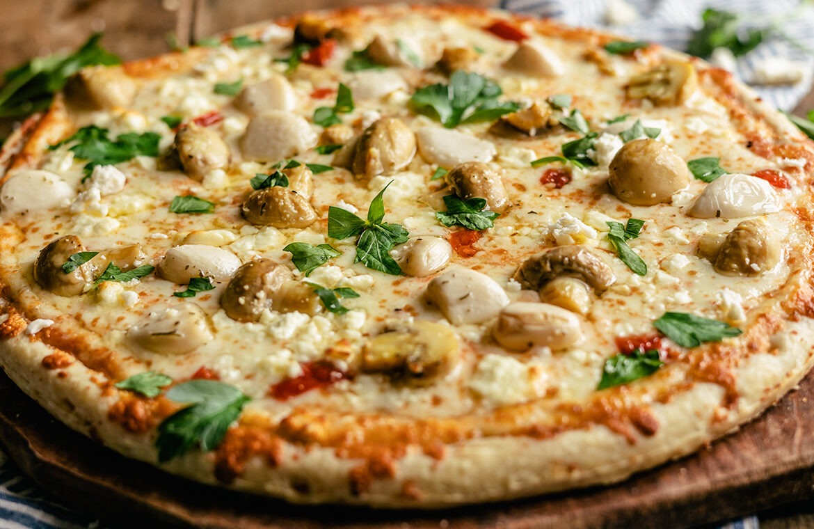 Pizza topped with mushrooms, feta, and garlic