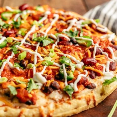 Pizza topped with chili and sour cream drizzle