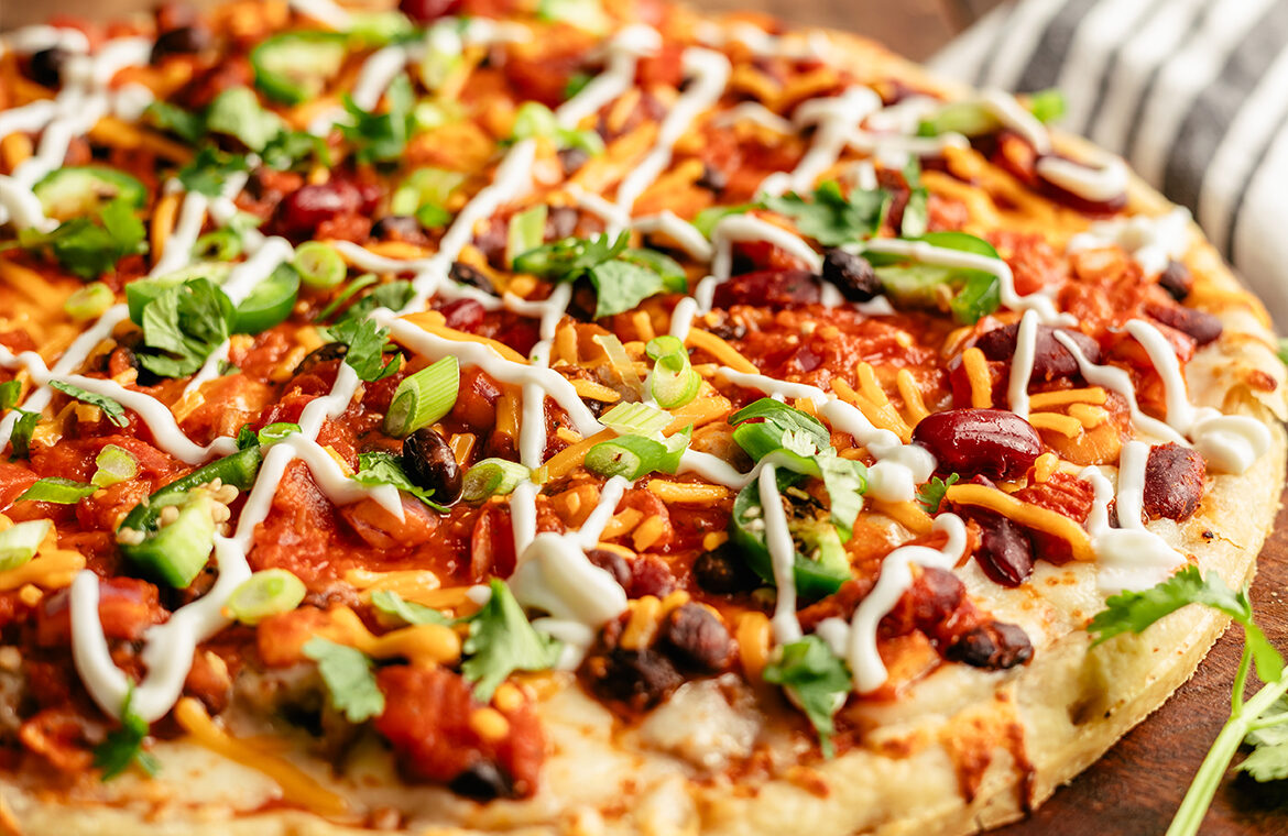 Pizza topped with chili and sour cream drizzle