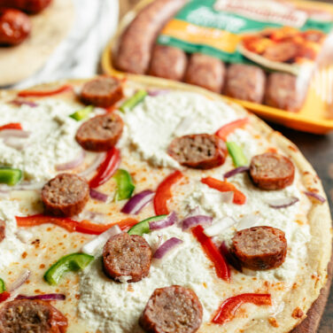 Pizza topped with Johnsonville Sausage, ricotta, onion, bell peppers