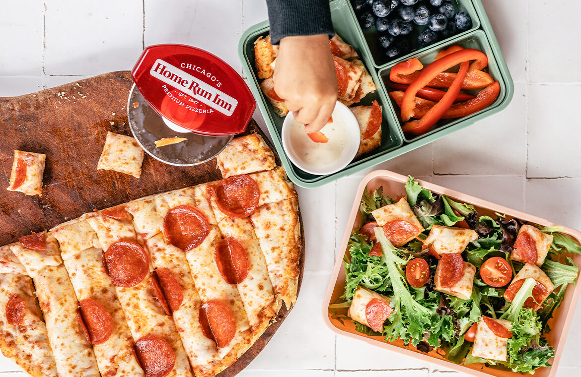 Kid's lunch and mom's lunch topped with bite size pizza slices