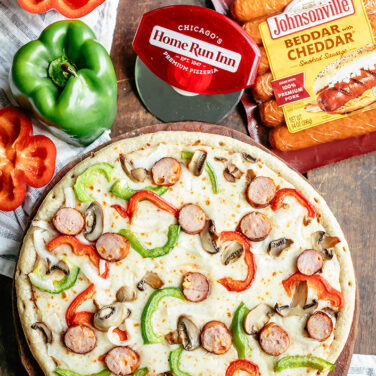 Pizza topped with Johnsonville Sausage, bell peppers