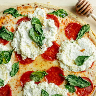Pepperoni Pizza topped with Hot Honey, Ricotta, and Spinach