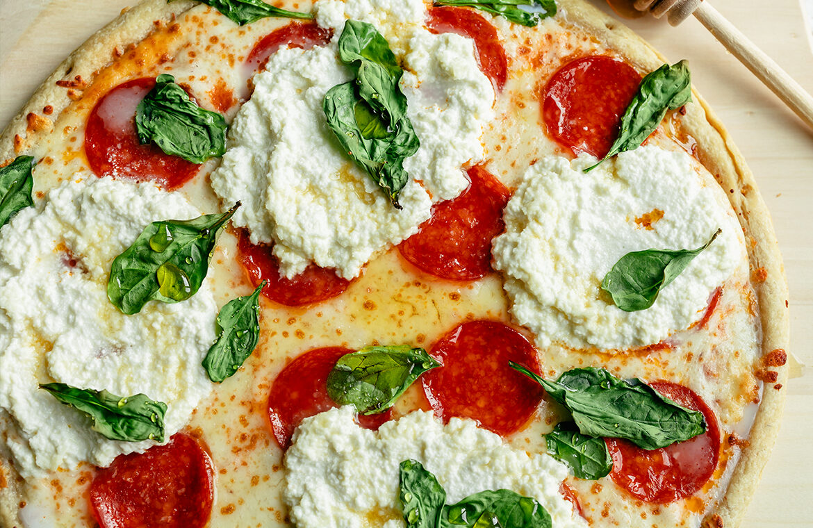 Pepperoni Pizza topped with Hot Honey, Ricotta, and Spinach