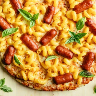 Baked pizza topped with mac n' cheese and lil' smokies