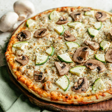 Baked Sausage Pizza topped with Zucchini, mushrooms, and Italian seasoning