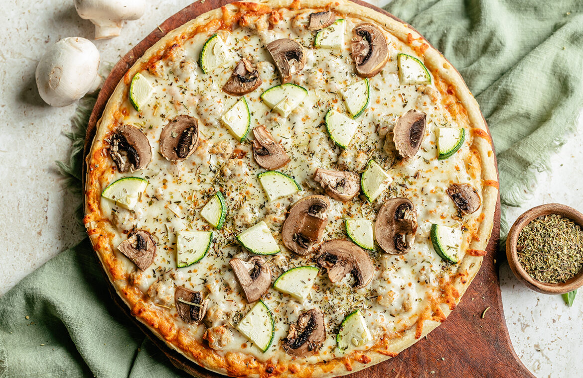 Baked Sausage Pizza topped with Zucchini, mushrooms, and Italian seasoning