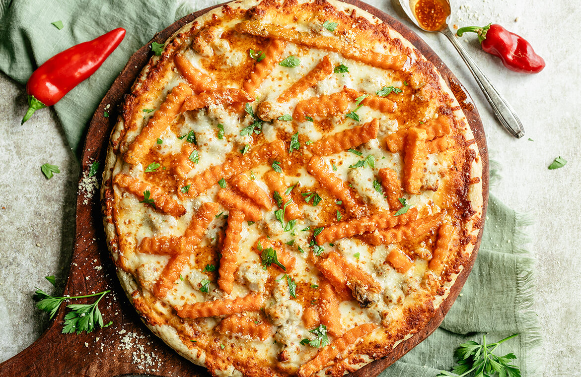 Baked pizza topped with crinkle cut sweet potato fries and chili infused oil