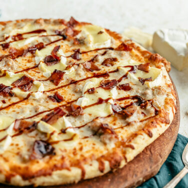 Baked pizza topped with Brie, Hot Honey, and bacon