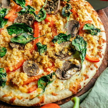 Baked pizza topped with lentils and veggies