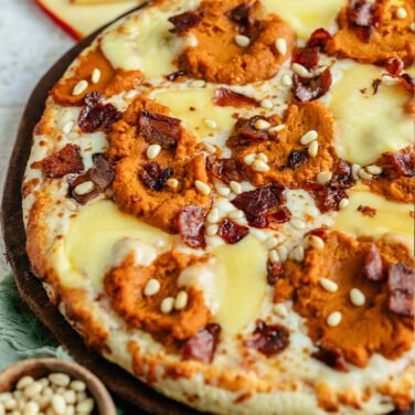 Baked pizza topped with gouda, pumpkin, and more