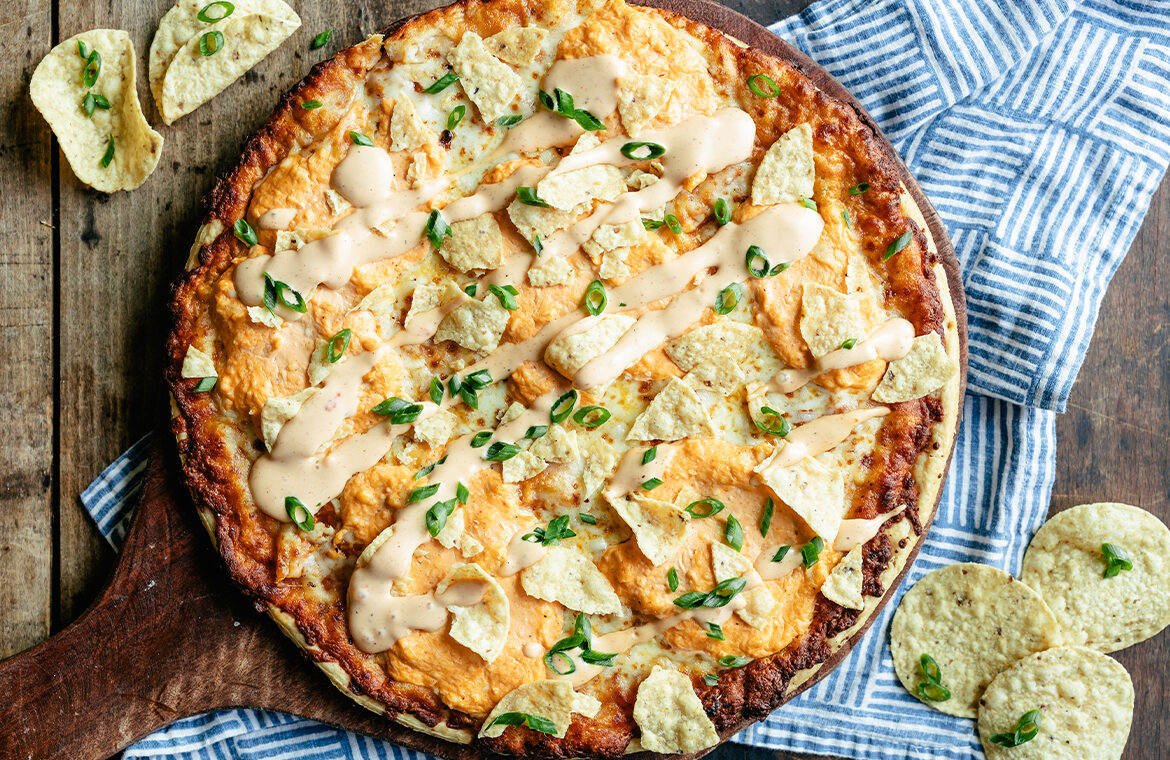 Baked Pizza topped with buffalo chicken dip and tortilla chips