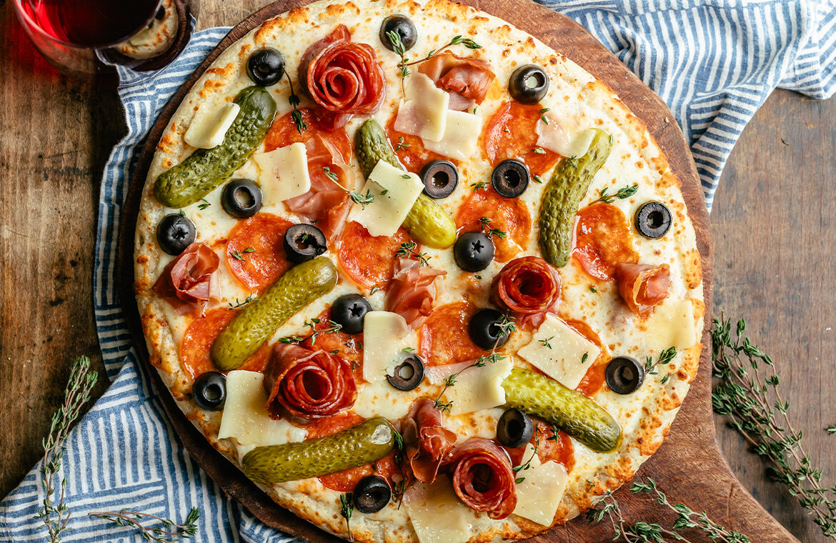 Baked pizza topped with charcuterie board ingredients