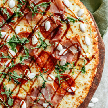 Baked Pepperoni Pizza topped with balsamic, kale, and prosciutto