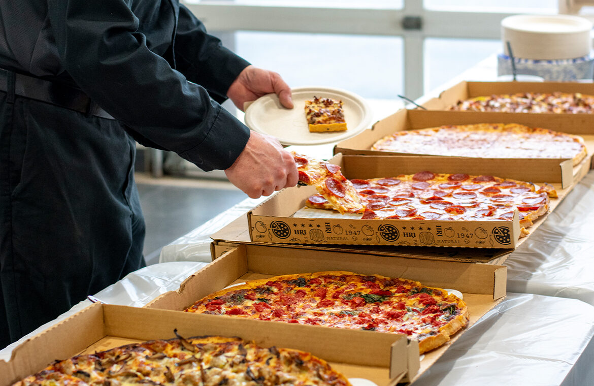 catering image of someone grabbing pizza