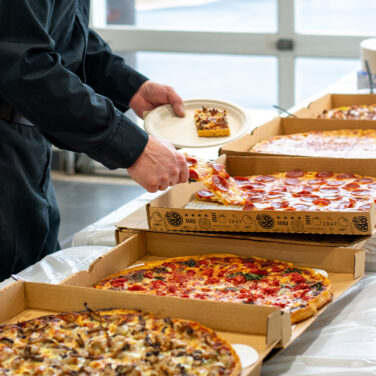 catering image of someone grabbing pizza