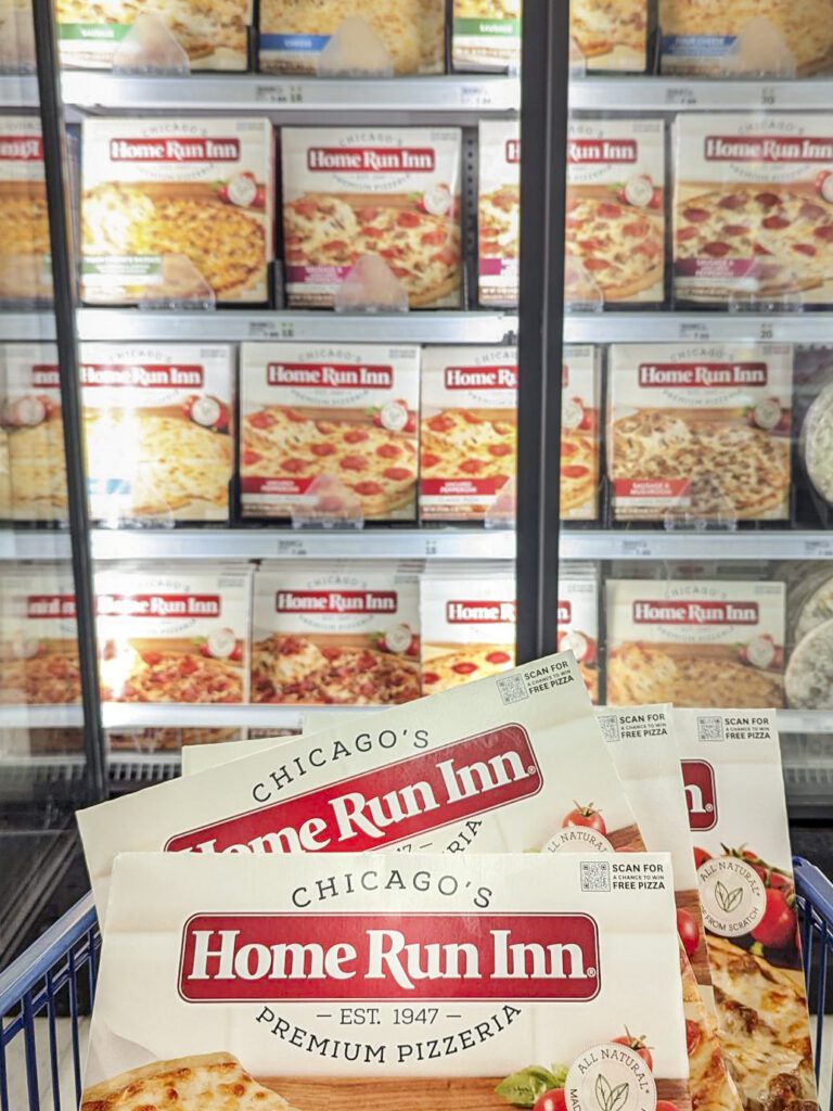 Home Run Inn frozen pizza boxes stocked on display shelves inside a grocery store freezer aisle.
