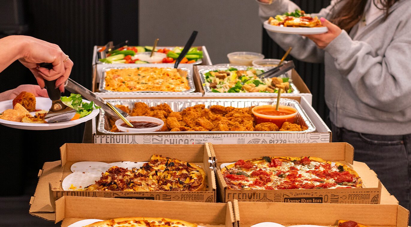 Catering spread with hands grabbing food
