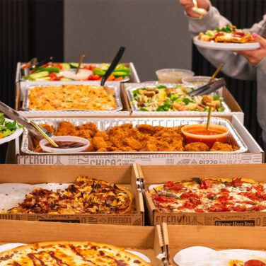 Catering spread with hands grabbing food