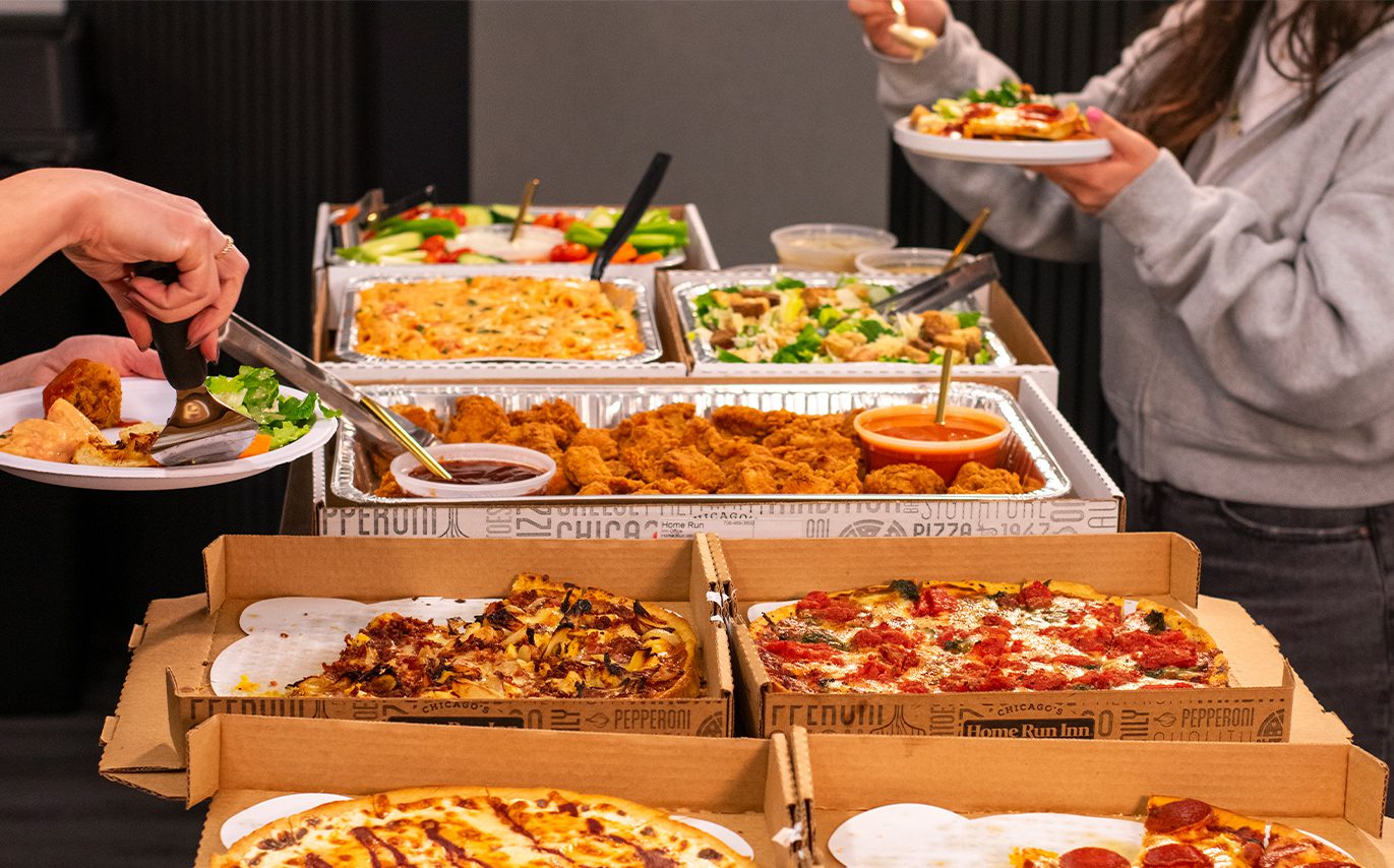 Catering spread with hands grabbing food